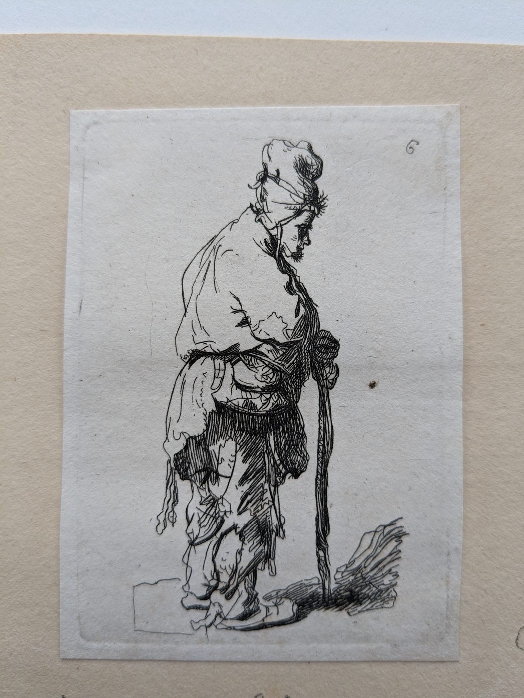 “A peasant in a high cap, standing leaning on a stick”